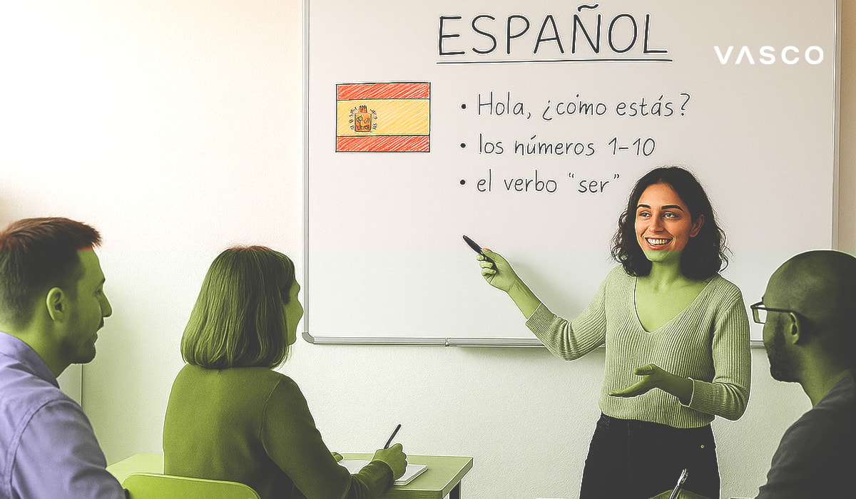 Tânără profesoară predând o lecție de spaniolă, arătând spre o tablă albă cu fraze de bază în spaniolă și un steag spaniol desenat de mână.