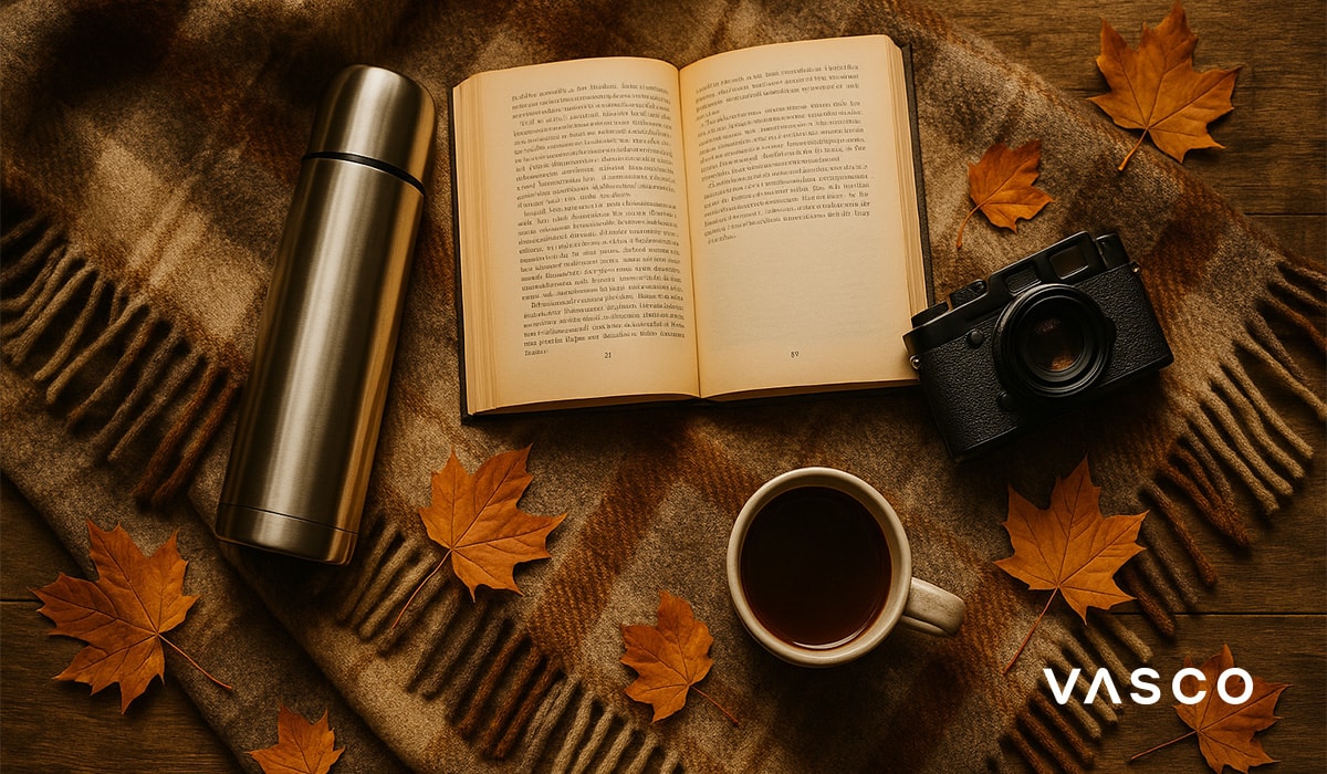 aranjament primitor de toamnă, cu o carte, un aparat foto, un termos și o ceașcă de ceai