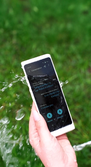 Prim-plan cu un Vasco Translator V4 stropit cu apă, pentru a evidenția rezistența acestuia.